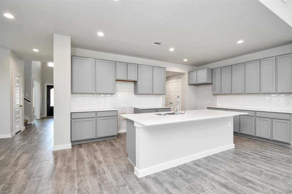 Discover another perspective of this stunning kitchen, generously appointed with an abundance of counter space