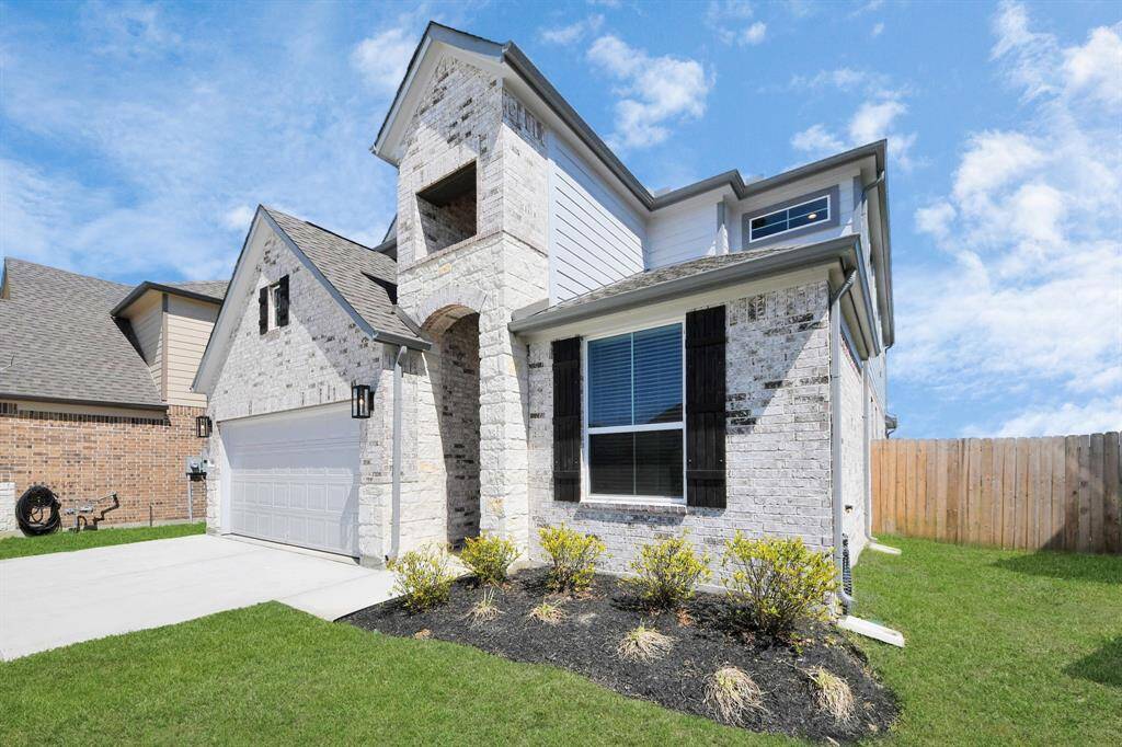 Behold a lush landscape, impeccably maintained yard, and a premium elevation adorned with captivating brick and stone features.
