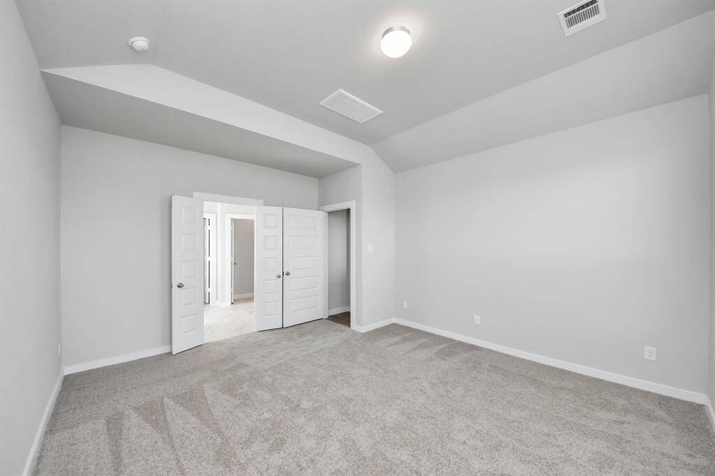 Escape and relax in the exquisite primary suite, a haven to unwind after a long day. The spacious room, located on first floor, boasts plush carpeting, soothing paint tones, high ceilings, and expansive windows adorned with privacy blinds.