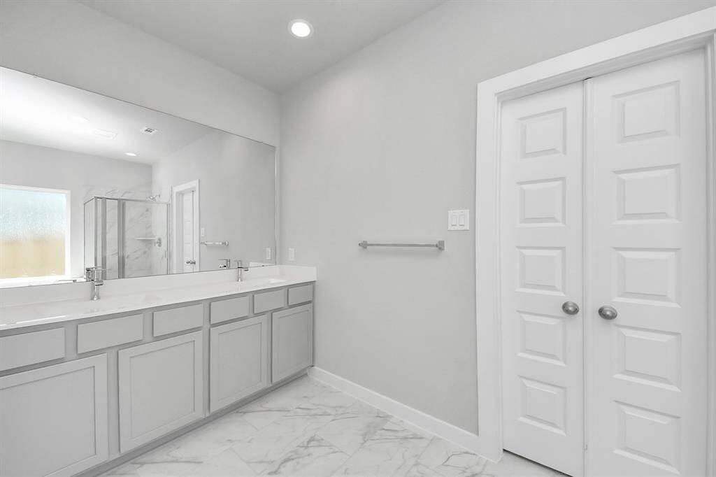 Escape to a spa-like oasis in this primary bathroom. Enjoy a walk-in shower with tile surround, a separate garden tub with custom detailing, and an elegant vanity featuring light countertops, modern hardware, and beautiful recessed lights. Experience luxury and relaxation in every detail.