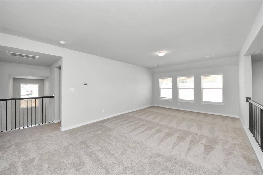 Come upstairs and enjoy a day of leisure in this fabulous game room! This is the perfect hangout spot or adult game room! Features plush carpet, high ceilings, custom paint and windows for plenty of natural light.