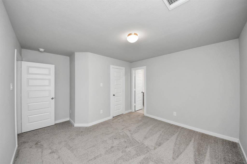 Secondary bedroom features plush carpeting, large windows that let in plenty of natural light, bright paint, and spacious closets.