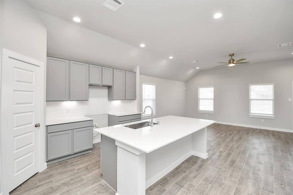 This kitchen is by far any chef’s dream! This spacious kitchen features high ceilings, lightstained wood cabinets, granite countertop, SS appliances, modern tile backsplash,recessed lighting, extended counter space, granite kitchen island with double sink, andspace for breakfast bar, and a walk-in pantry all overlooking your huge family room.