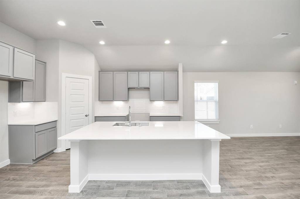 The kitchen is a culinary haven, featuring granite countertops, a tile backsplash, stainlesssteel appliances, 42” upper cabinets, and undercabinet lighting.