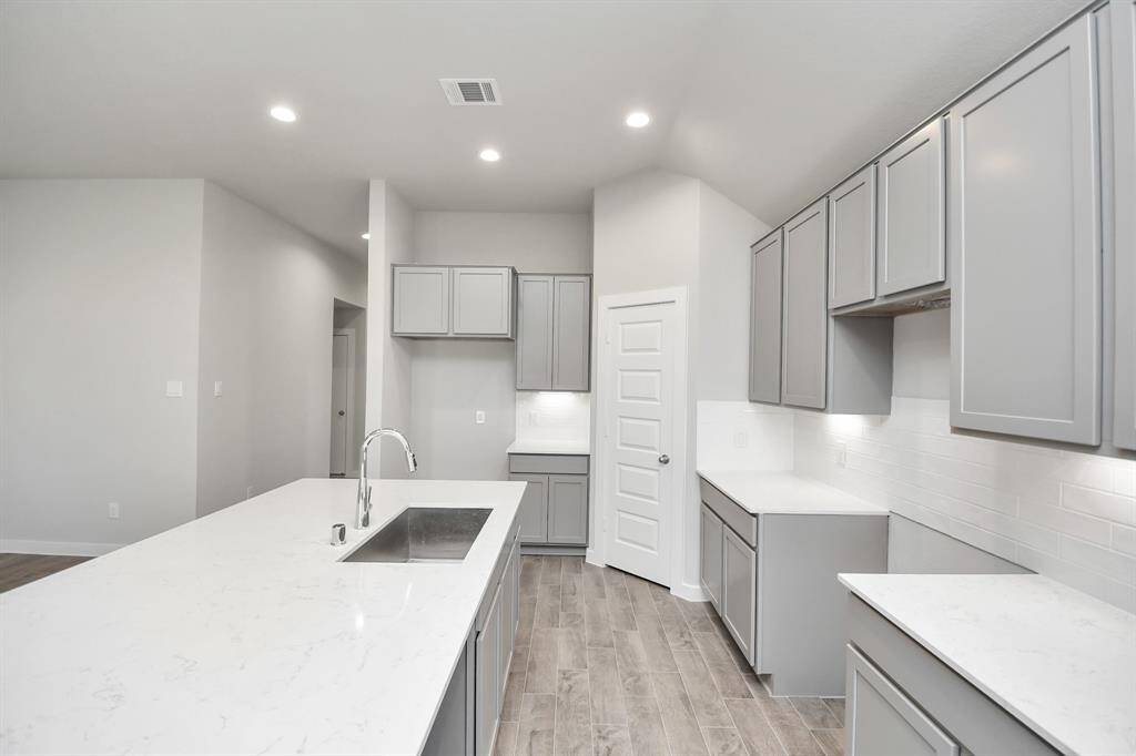 With a massive granite island, highceilings, soft close cabinets, granite countertops, stainless steel appliances, a sleek tilebacksplash, recessed lighting, and an extended counter area, it offers both style andpracticality.