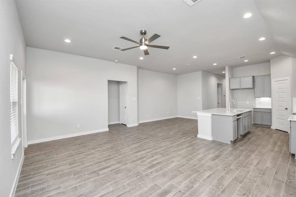 Relax and unwind in this inviting family room, illuminated by abundant naturallight streaming in through tall windows, complemented by high ceilings andstunning flooring.