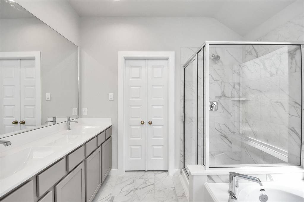 Delight in a spacious walk-in shower enveloped in stylish tile surround, and unwindin a separate garden tub adorned with custom detailing.
