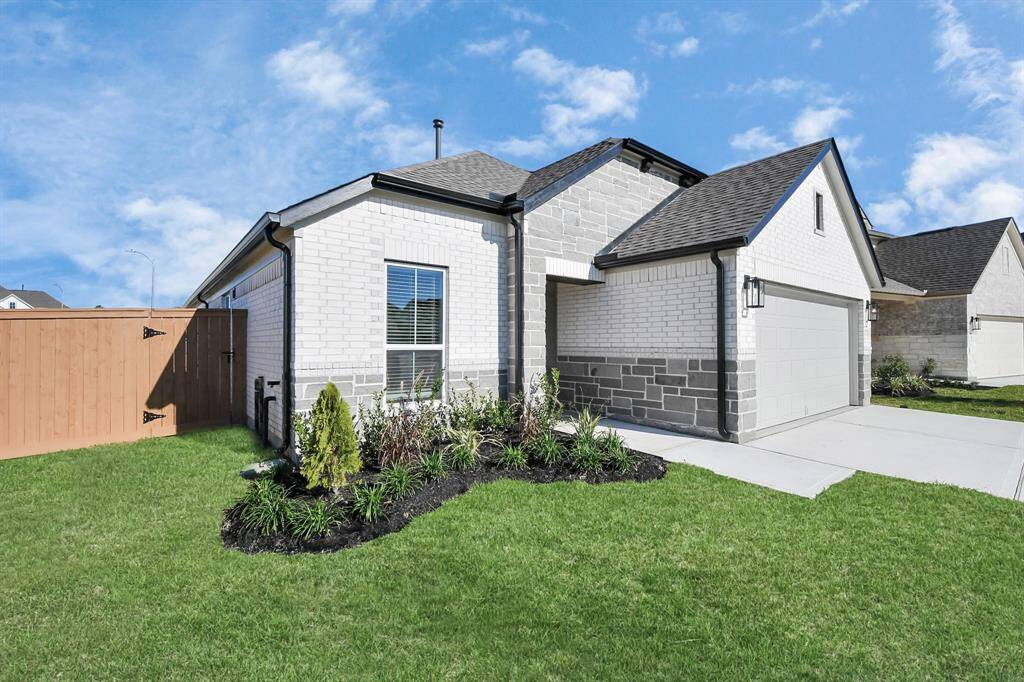 Behold a lush landscape, impeccably maintained yard, and apremium elevation adorned with captivating brick and stone features.