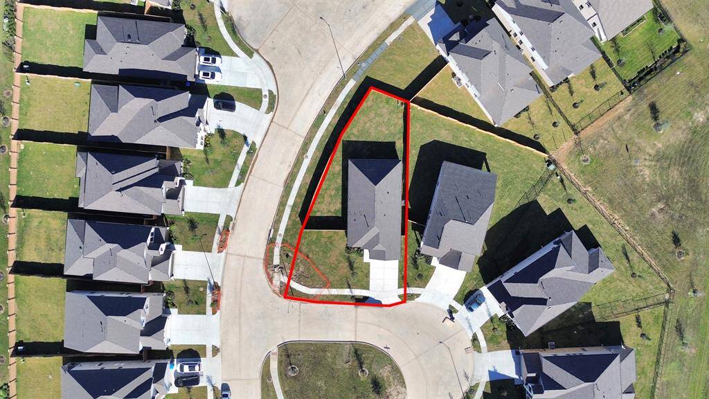 An aerial view of a spacious subdivision lot, highlighting a well-maintained yard and a fully fenced perimeter, offering both privacy andexpansive outdoor space.