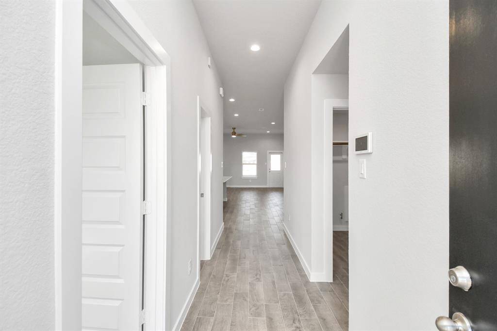 As you step into the threshold of this luxurious home, you'll soon be welcomed by an elegant glass door. Inside, soaring ceilings amplify the spaciousness, while the refined wood-look tile flooring and oversized baseboards exude sophistication and charm.