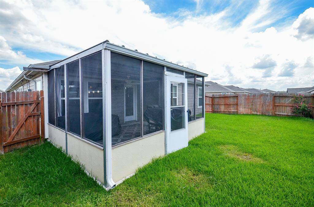 View of back yard, and screened patio.