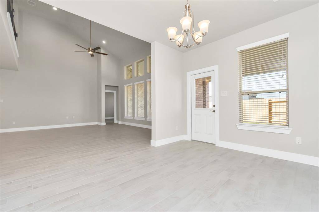 This seamless open concept ensures a connected flow between the family room, kitchen, and this dining area. The back door, adorned with a window for natural light, opens gracefully to the covered patio. Actual interior color and selections may vary.