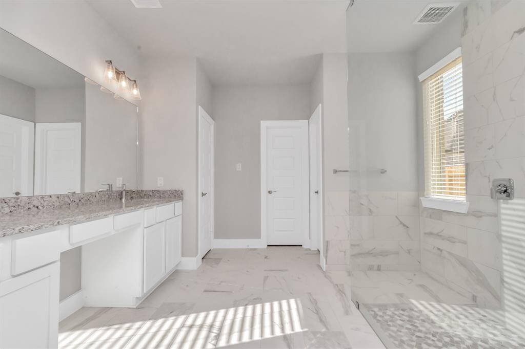 Indulge in the luxurious ambiance of this primary ensuite, reminiscent of a personal spa retreat. Enjoy a walk-in shower with tasteful tile surround. Ultimate relaxation after a long day.  Sample photo, as built color and selections may vary.