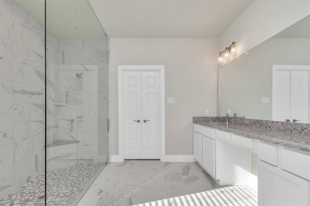 Luxurious walk-in shower, featuring spacious bench seating for added comfort and indulgence. A perfect blend of style and functionality, creating a spa-like retreat in the comfort of your own home.  Sample photo, as built color and selections may vary.