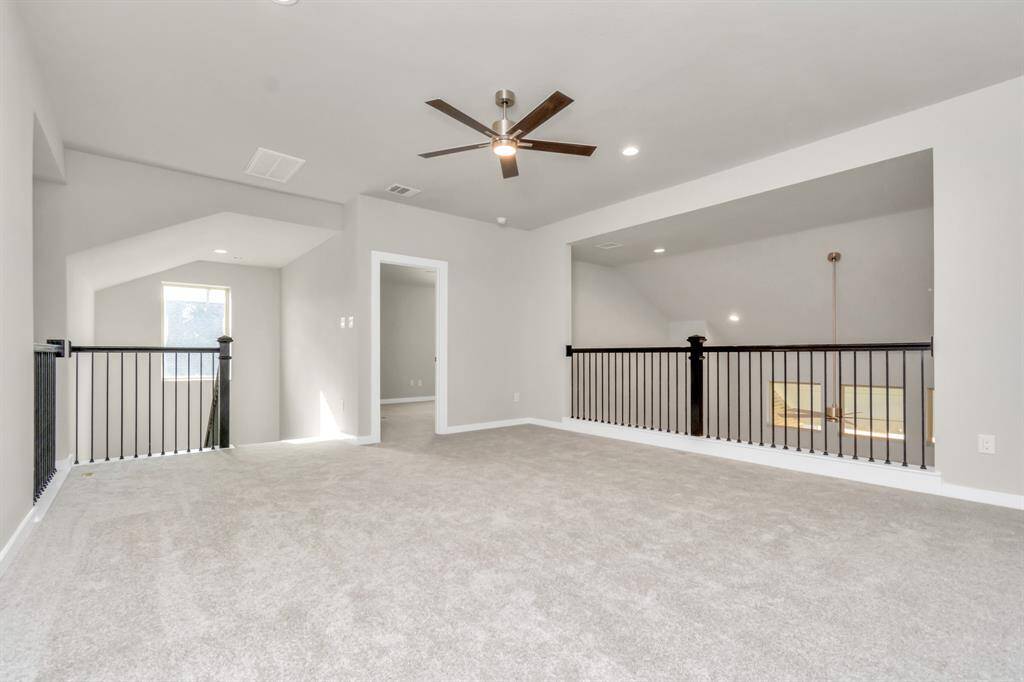 Elevate your leisure in this fantastic game room! Perfect for casual gatherings and adult gaming, it features plush carpet, high ceilings, custom paint, and numerous windows that welcome in ample natural light.  Sample photo, as built color and selections may vary.