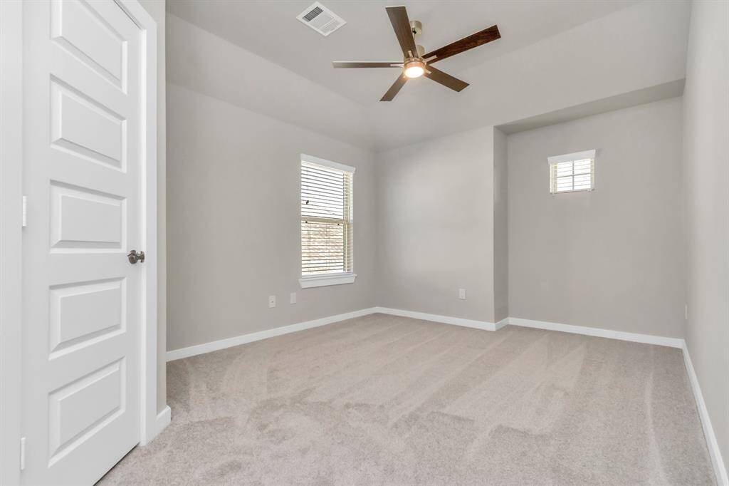Elegance meets functionality in the generously sized secondary bedrooms, showcasing 5-panel doors with modern hardware, large windows adorned with privacy blinds, and spacious closets boasting sleek and contemporary finishes.  Sample photo, as built color and selections may vary.