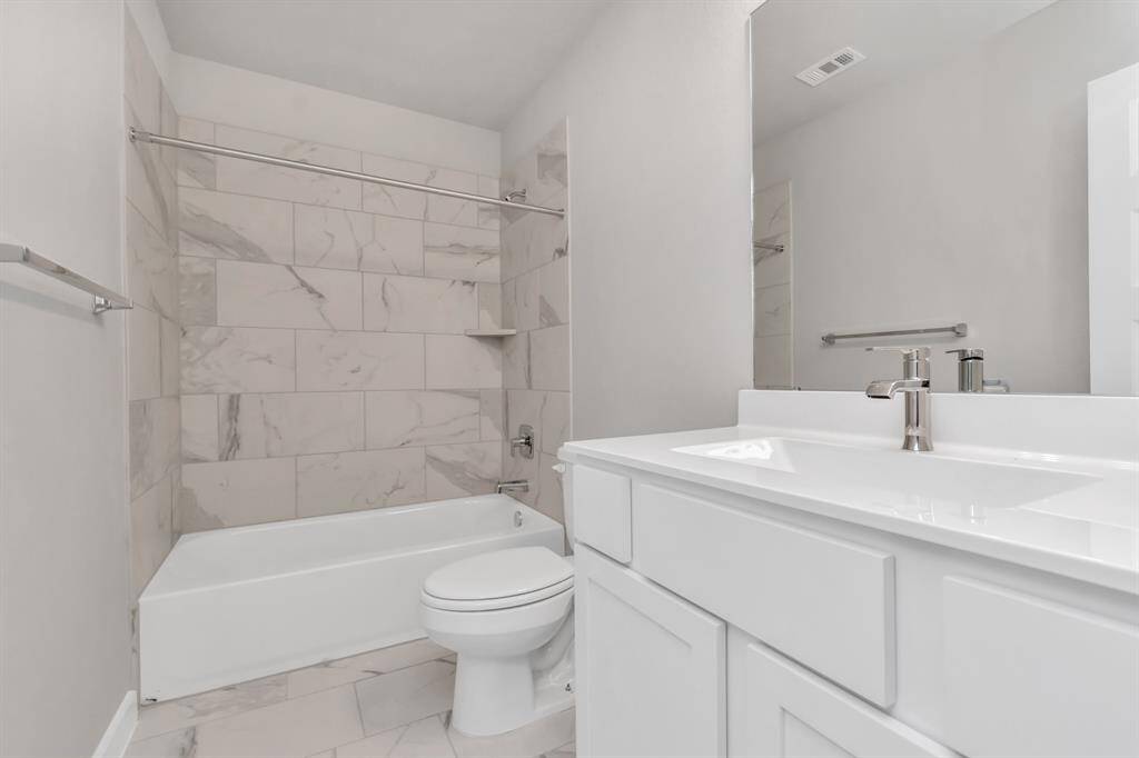 Experience sophistication in the secondary bathrooms, where tile flooring complements a bath/shower combo with tile surround. Light wood cabinets complete with a beautiful light countertop, enhances the space for a truly inviting ambiance.  Sample photo, as built color and selections may vary.