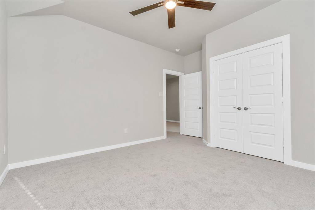 Elegance meets functionality in the generously sized secondary bedrooms, showcasing 5-panel doors with modern hardware, large windows adorned with privacy blinds, and spacious closets boasting sleek and contemporary finishes.  Sample photo, as built color and selections may vary.