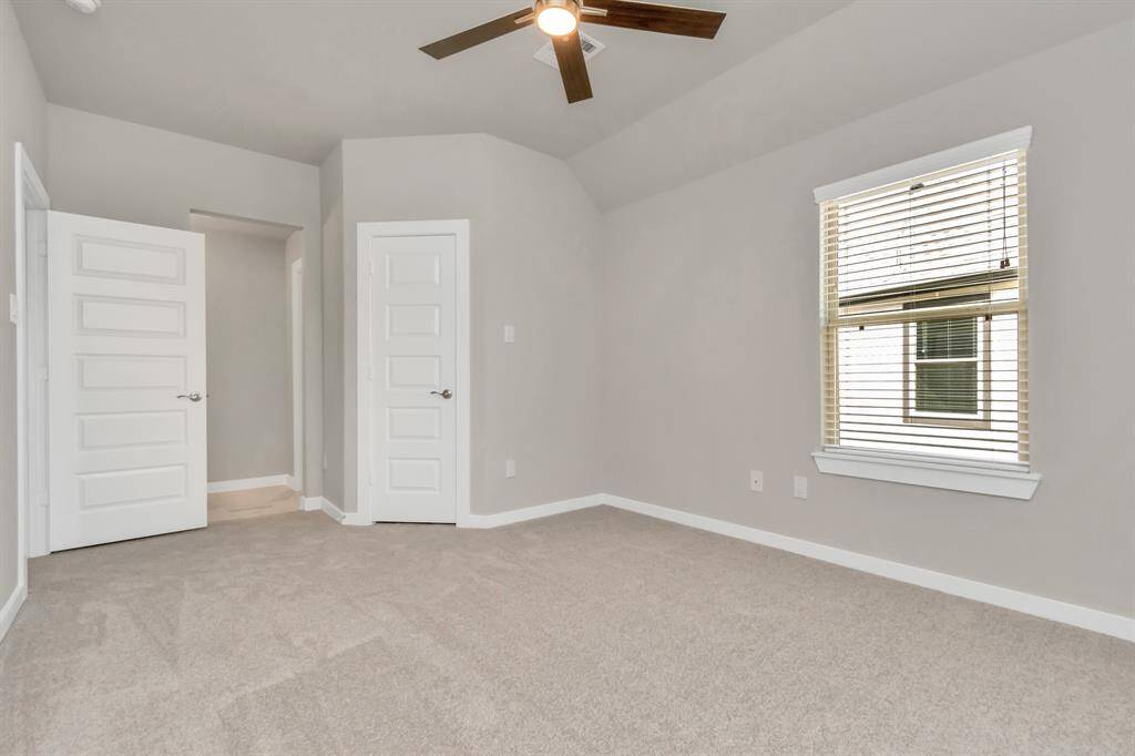 Elegance meets functionality in the generously sized secondary bedrooms, showcasing 5-panel doors with modern hardware, large windows adorned with privacy blinds, and spacious closets boasting sleek and contemporary finishes.  Sample photo, as built color and selections may vary.