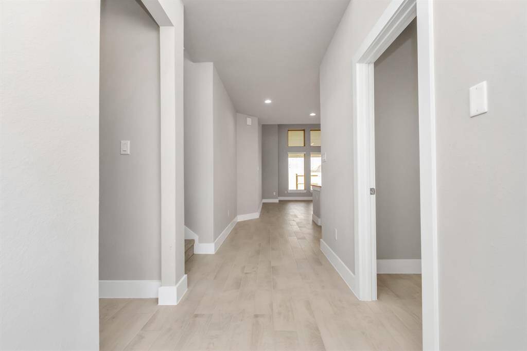 Indulge in luxury as you step into the threshold of this breathtaking home. The grand entrance beckons with its soaring ceilings, adorned with elegant wood-look tile flooring & sleek oversized baseboards. Follow the path of natural light streaming through expansive windows as you make your way to the family room, creating an inviting and warm atmosphere. Sample photo, as built color and selections may vary.
