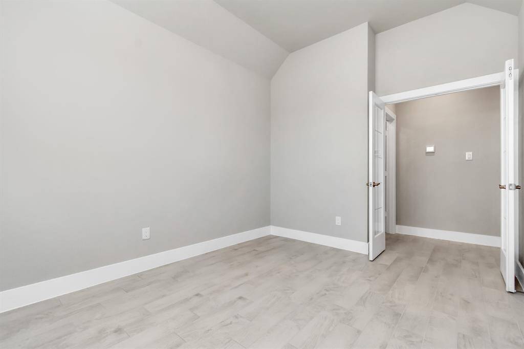 At the forefront of the home, a refined home office beckons productivity and focus. Luxurious details like tile flooring, custom paint, expansive windows with privacy blinds, and French doors create an inspiring workspace. Sample photo, as built color and selections may vary.