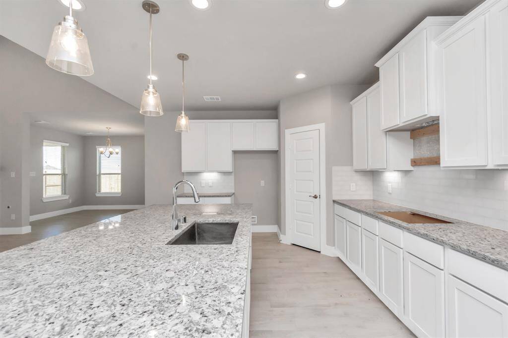Additional view of your culinary haven with tons of counter space.  Sample photo, as built color and selections may vary.