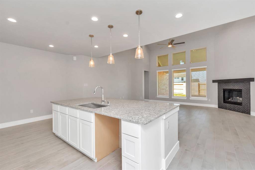 Kitchen opens up to the expansive family room, creating a perfect hub for gatherings.  Sample photo, as built color and selections may vary.