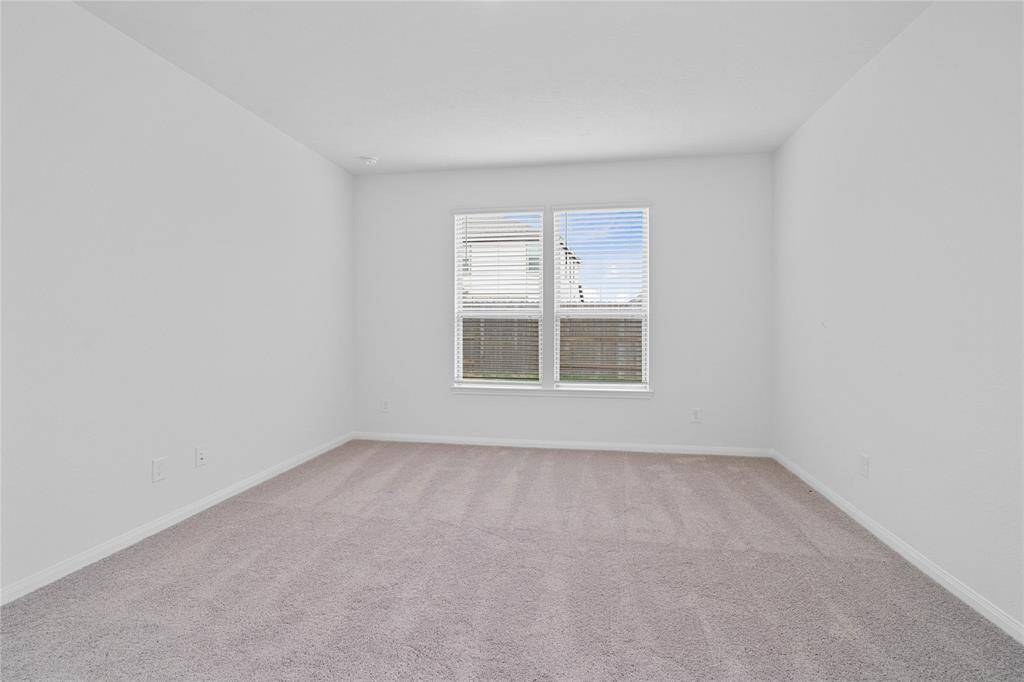 What a wonderful place to come home to, this stunning primary suite greets you with plush carpet, a warm custom paint, high ceiling, and large windows with 2" faux wood blinds, allowing in natural light brightening up this spacious room.