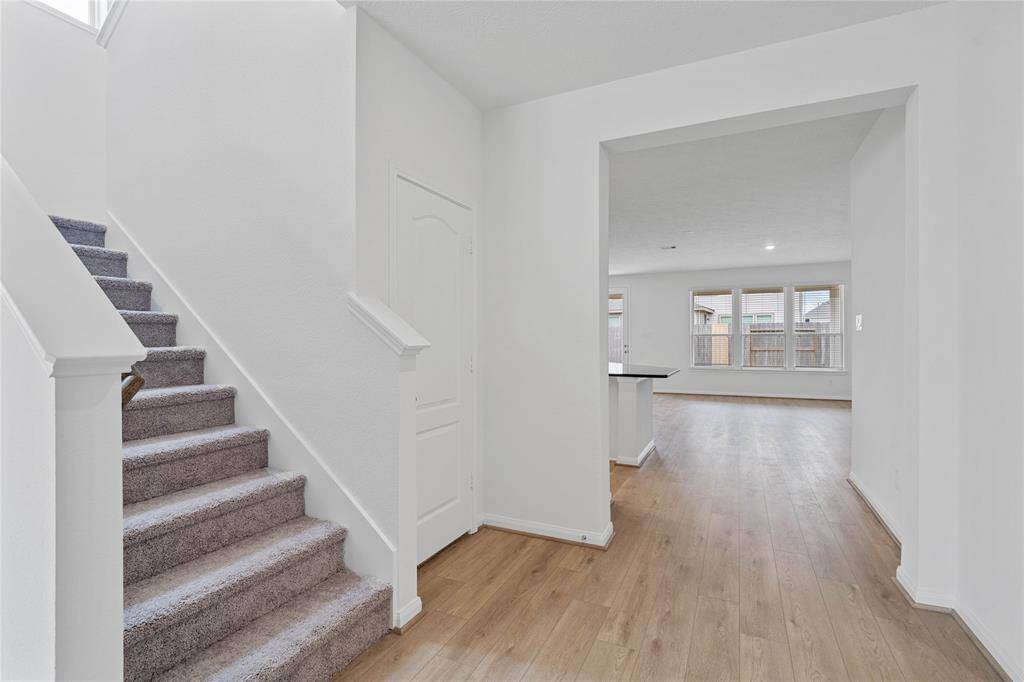 Come inside 7722 Coral Key Drive where the entryway is bright and open! Featuring vinyl plank flooring, stair closet, and custom neutral paint!