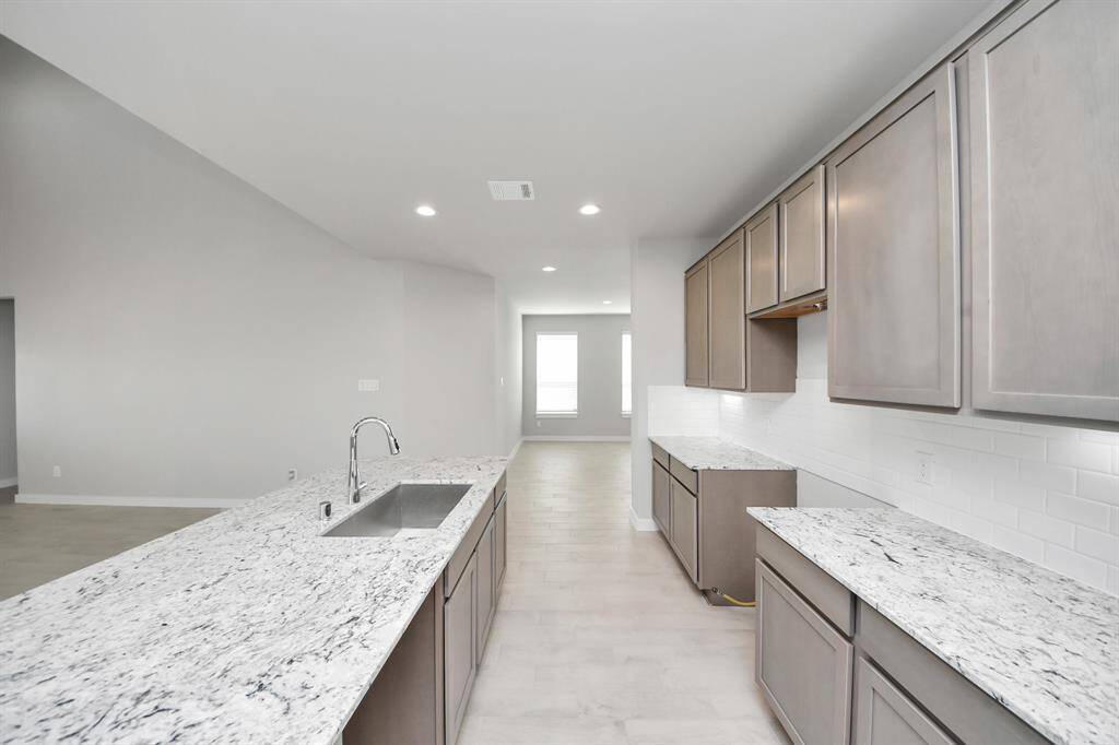 Discover another perspective of this stunning kitchen, generously appointed with an abundance of counter space!