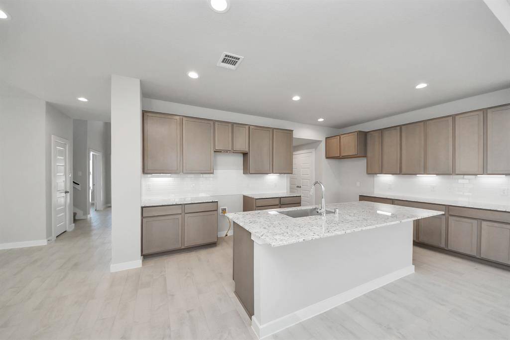 Gather the family and guests together in your lovely living room! Featuring soaring high ceilings, recessed lighting, ceiling fan, custom paint, gorgeous floors, and large windows that provide plenty of natural lighting throughout the day.