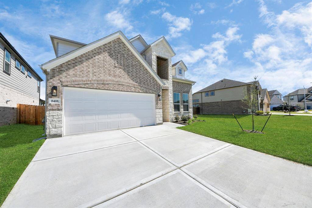 This home boasts lush green grass and meticulous landscaping. Its premium elevation showcases an exquisite blend of brick and stone features, complemented by modern coach lighting