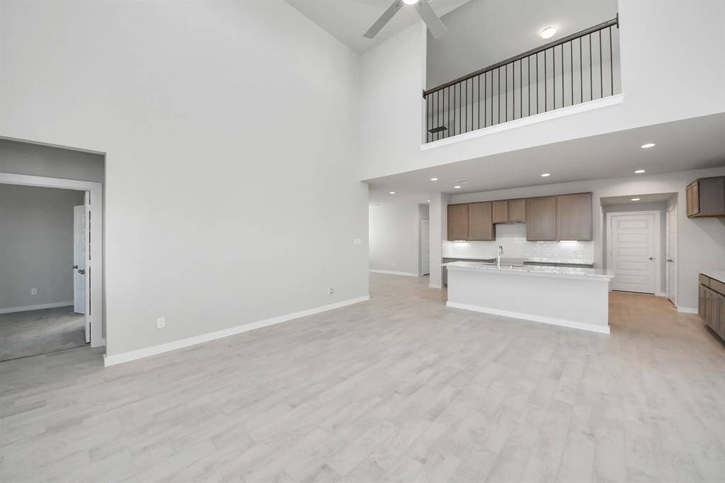 Escape and relax in the exquisite primary suite, a haven to unwind after a long day. The spacious room, located on first floor, boasts plush carpeting, soothing paint tones, high ceilings, and expansive windows adorned with privacy blinds.