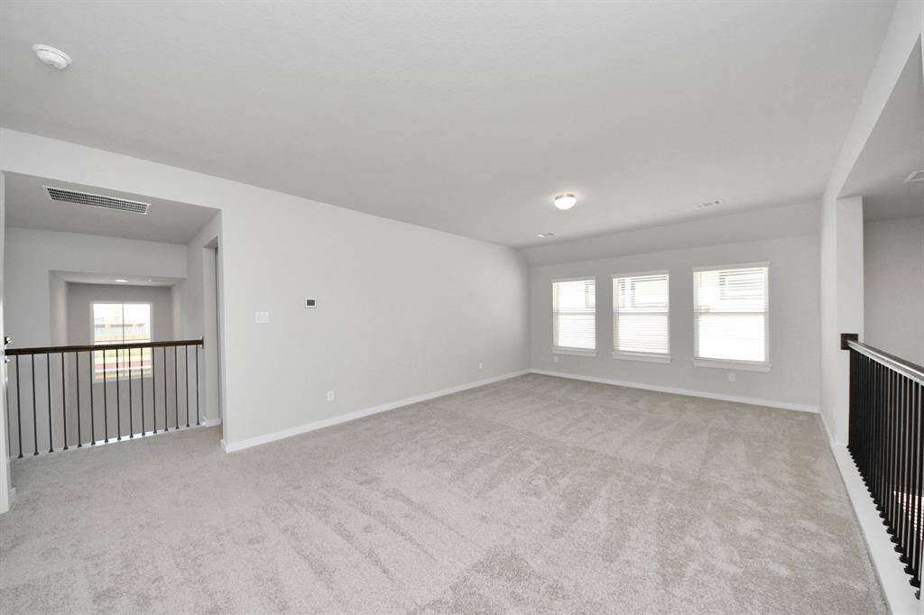 Ascend to relaxation in this fantastic game room! Ideal for both casual gatherings and adult gaming, it boasts plush carpet, lofty ceilings, custom paint, and ample windows for abundant natural light.