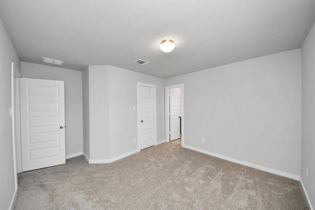 Secondary bath features tile flooring, bath/shower combo with tile surround, light stained wood cabinets, beautiful light countertop.
