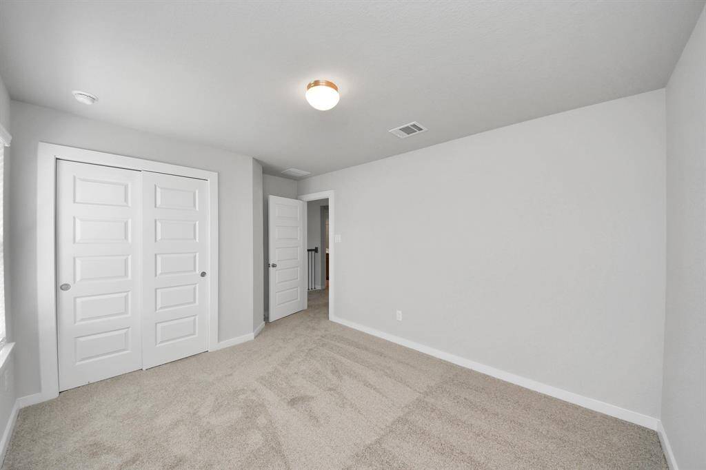 Secondary bath features tile flooring, bath/shower combo with tile surround, light stained wood cabinets, beautiful light countertop.