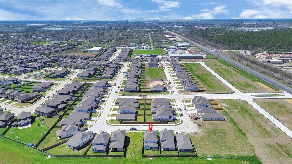 An aerial view of a spacious subdivision lot, highlighting a well-maintained yard and a fully fenced perimeter, offering both privacy and expansive outdoor space.