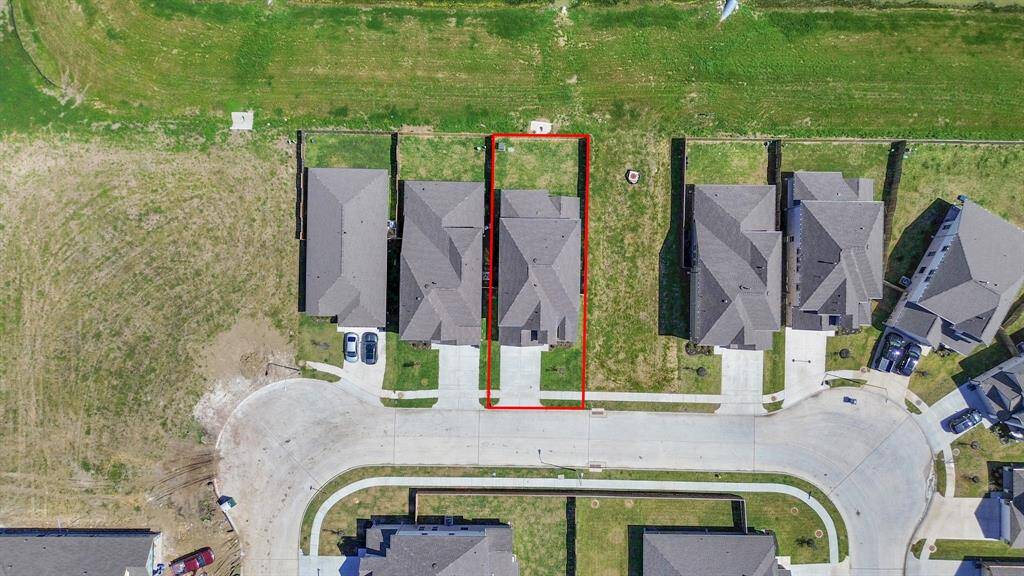 An aerial view of a spacious subdivision lot, highlighting a well-maintained yard and a fully fenced perimeter, offering both privacy and expansive outdoor space.