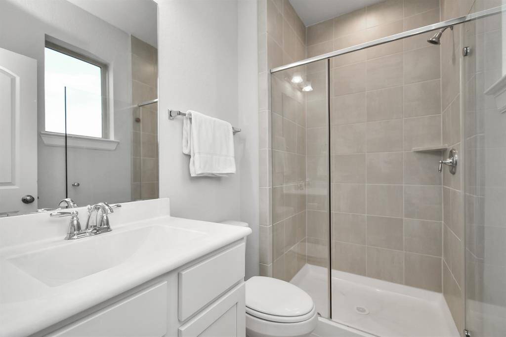 The first-floor ensuite bathroom offers lovely natural light and showcases sleek, modern finishes - the oversized walk-in shower is also a wonderful feature!