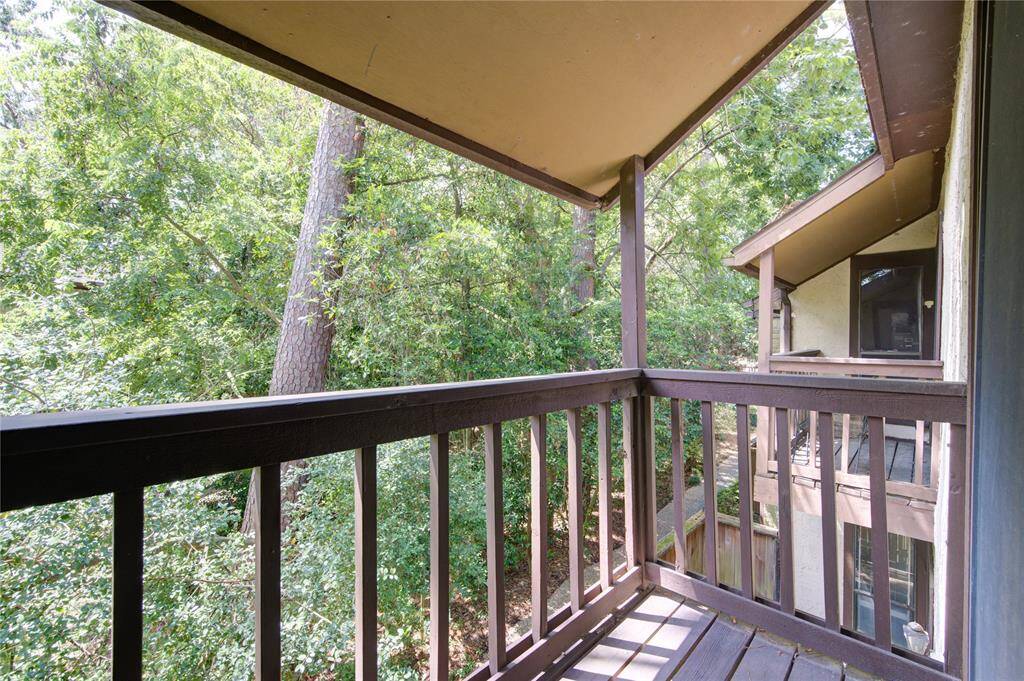 The second-floor primary bedroom features a private balcony overlooking a serene wooded area, offering an exceptionally quiet and private retreat that seamlessly connects indoor comfort with outdoor relaxation.