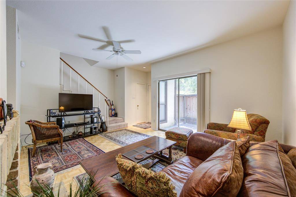 Upon entry, you'll find a convenient half bath and a spacious living room with a cozy fireplace to the left, all bathed in natural light. The living area opens to a large, fenced porch, and stairs lead gracefully to the second floor.