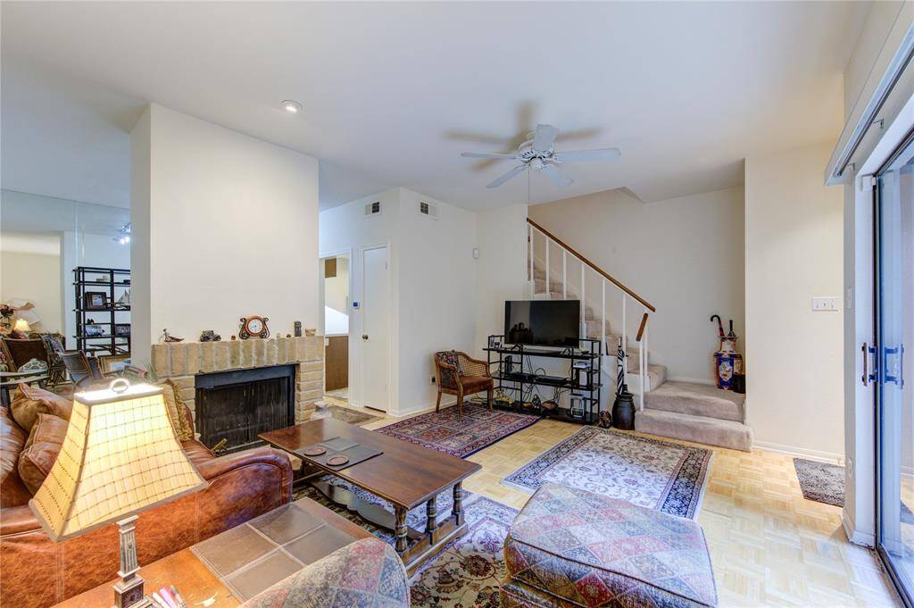 Another view of the living room reveals a cozy fireplace and an open connection to the breakfast/dining room and kitchen. To the left, a convenient closet adds to the functionality of this inviting space.