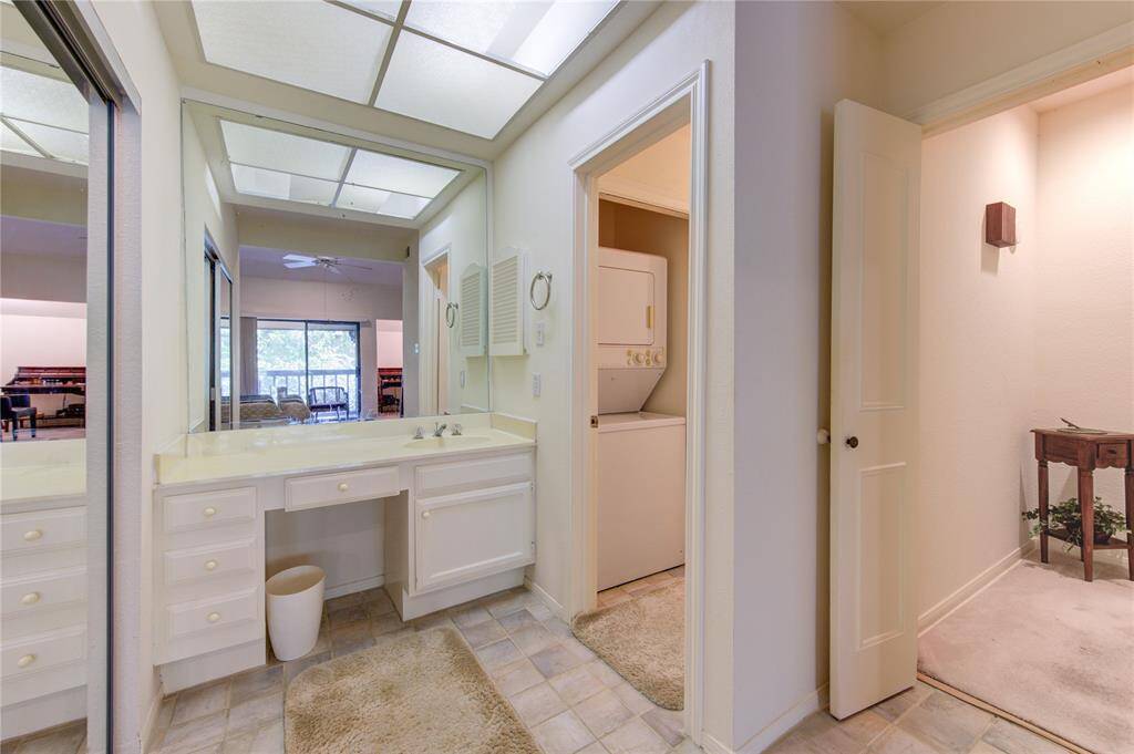 This residence features a convenient vanity area with the primary bathroom just to the left, complete with a functional stackable washer and dryer. A set of stairs leads you down to the inviting 1st floor, offering a seamless blend of practicality and comfort.