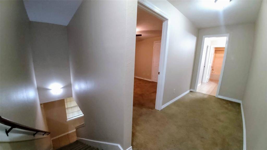 View your stylish apartment from the top of the staircase.  From here, you can see the lovely first bedroom, spacious hallway, chic vanity area, cozy second bedroom, and full bath.