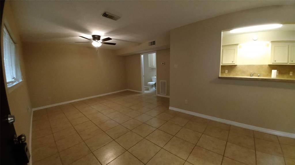 Left of the entry way, is the living room with ceiling fan and convenient access to the half bath.