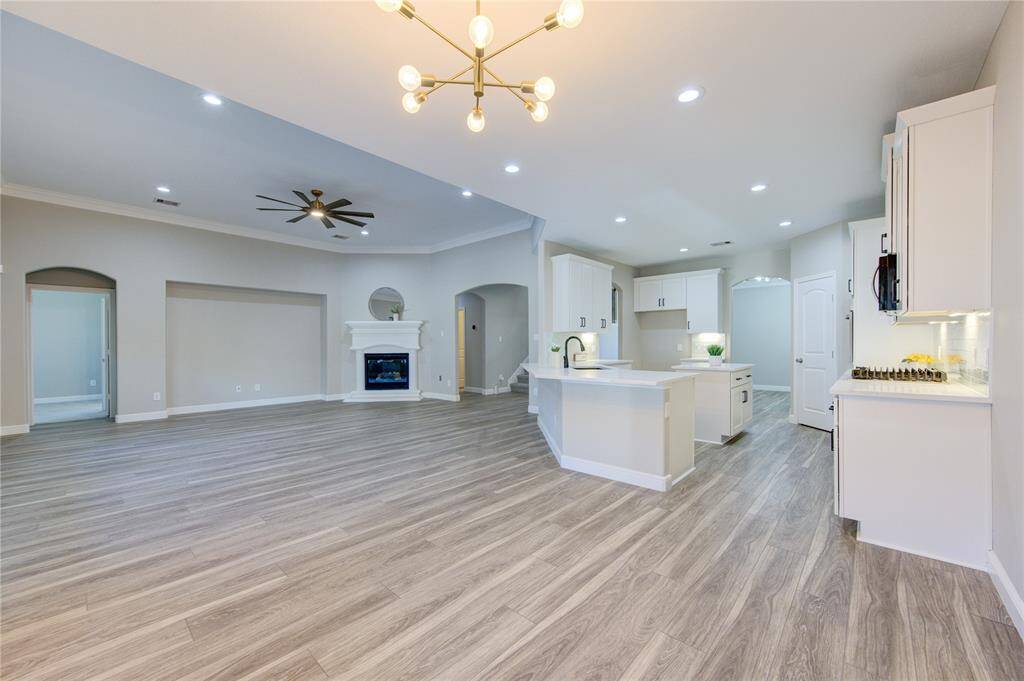 View from breakfast area (updated lighting) into Primary Bedroom entrance, Living Room, and Kitchen