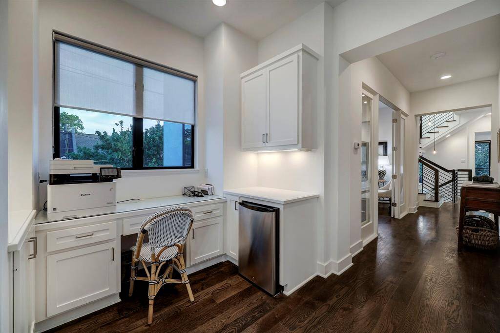 View of staircase to second level landing area with hardwood flooring, contemporary light fixtures and recessed lighting.
