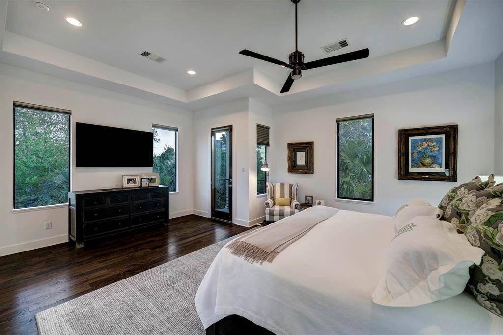 Primary suite is a generous size, with boxed ceiling detail, a small private balcony, great treetop views and sightlines to this corner lot location.