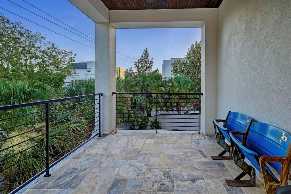 Third level outdoor covered deck space off of studio space features bead board ceiling, tile flooring and recessed lighting.