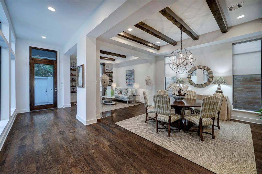 Closer view of dining space, large enough to accommodate any type of table arrangement. Decorative chandelier and beams add so much interest. Hardwood flooring throughout first level.